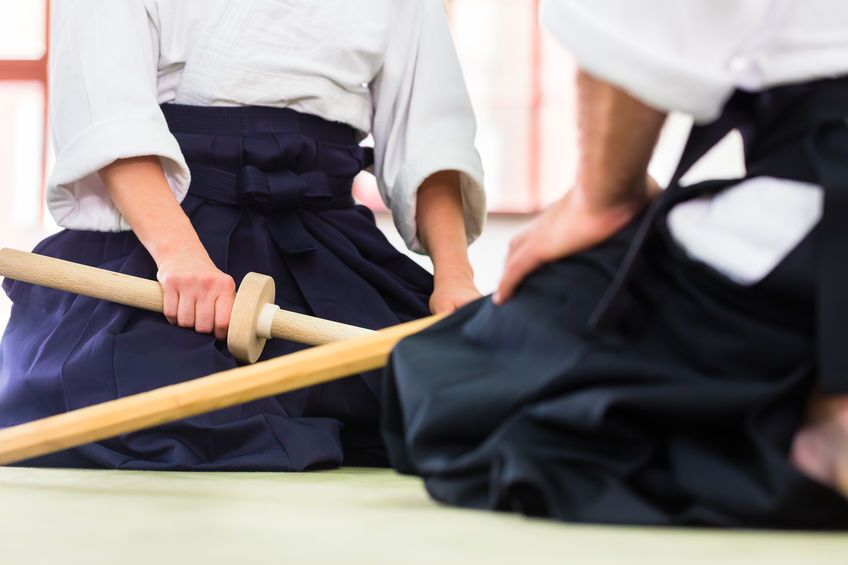 Deux pratiquants en hakama assis sur le tatami, bokken posé devant eux